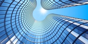 Glass of skyscrapers viewed from below with the bright sun shining above